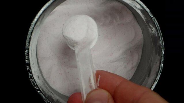 Dolly Zoom, Container With White Creatine Powder, Sports Supplement, Scooping Some Into A Spoon.