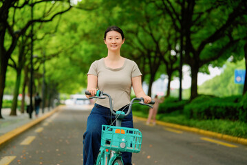 Woman Cycling on a Tree-Lined Pathway