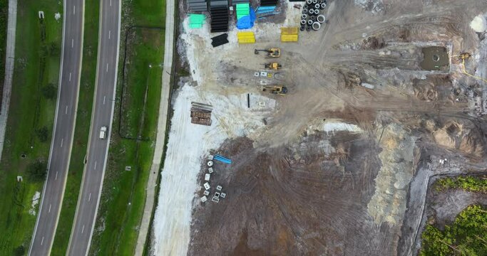 Development of residential housing in US suburbs. Beginning of construction works on prepared ground. Large building site with scattered equipment in American rural area. Real estate market in USA