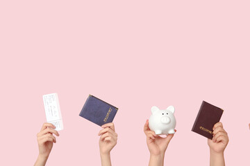 Female hands with ticket, passports and piggy bank on beige background. Travel concept