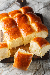 Hawaiian sweet rolls, portuguese sweet bread, soft and stretchy buns closeup on the wooden board on...