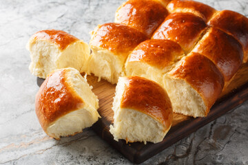 Homemade Baked Sweet Hawaiian Buns Ready to Eat closeup on the wooden board on the table. Horizontal