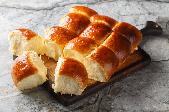 Homemade Freshly baked soft Dinner Rolls or Hawaiian Buns closeup on the wooden board on the table. Horizontal