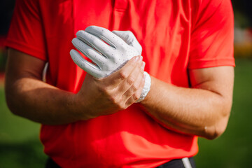 Sigulda, Latvia - September 10, 2023 - Close-up of a golfer in a red shirt putting on a white...