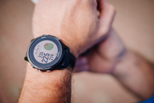 Sigulda, Latvia - September 10, 2023 - Close-up of a golfer's wrist wearing a Garmin golf watch, displaying hole information and distances...