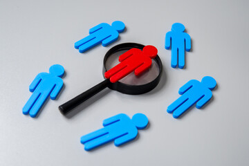 Human figures and magnifying glass. Find the culprit, suspect concept.