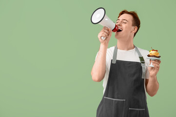 Male confectioner with megaphone and delicious profiterole on green background