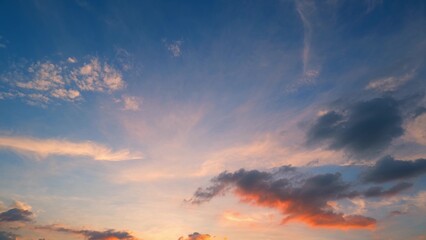 A beautiful sunrise with a sky that transitions from deep blue to soft pinks and oranges. Wispy clouds are illuminated by the rising sun, creating a peaceful and captivating scene. Cloud background.
