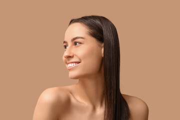 Young dark-haired woman on beige background