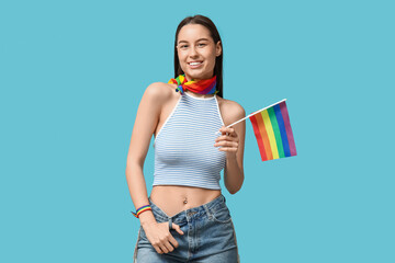 Beautiful young happy woman with piercing navel and LGBT flag on blue background