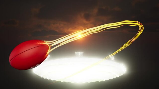 A Aussie Rules Football sport ball flying through the air with a flowing travelling trail of glowing wispy lights from a stadium  illuminated by an array of spotlights in the night time 