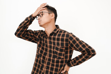 a young man wearing a flannel shirt, wearing glasses pats his head (forgotten expression). With a...