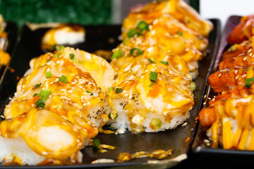 A plate of sushi with a lot of sauce on it. The sauce is yellow and brown