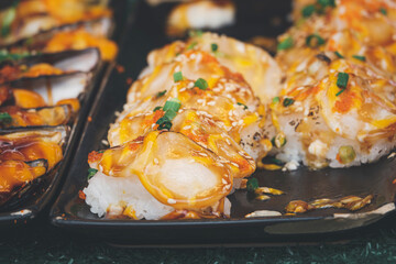 A plate of sushi with a lot of sauce and garnish