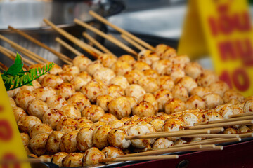 A tray of food with skewers on it. The skewers are made of bamboo and the food is cooked