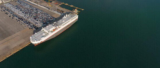 Aerial drone photo of large car carrier ro ro vessel guided by tug boats to dock to Mediterranean...