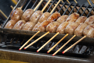 A grill with skewers of meat on it