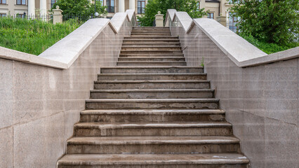 Modern stone staircase with stone railing goes up.