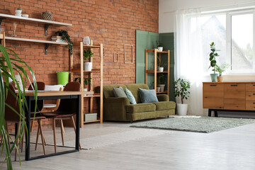 Shelving unit, cozy sofa and dining table in interior of living room