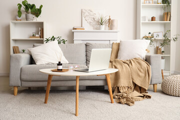 Reed diffuser and laptop on coffee table at home