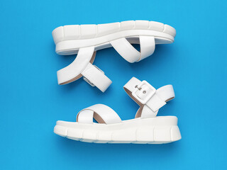 White Casual Summer Sandals on Blue Background Stylish Footwear for Warm Seasons