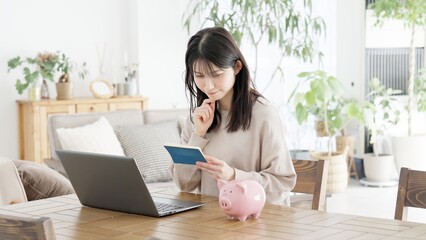通帳の残高の心配をする女性