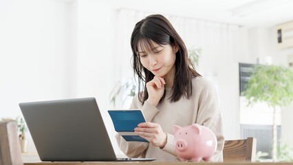 通帳の残高の心配をする女性