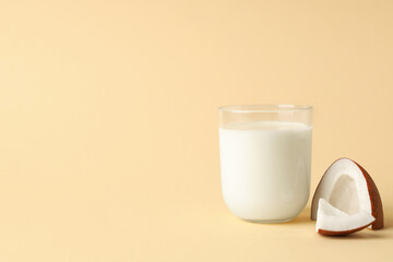 Glass of coconut milk on beige background