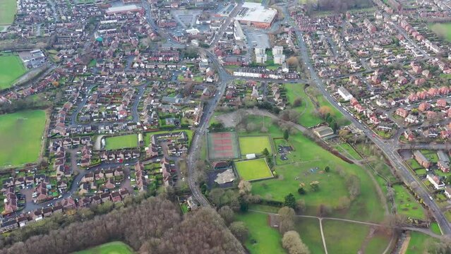Aerial footage of the town centre of the town of Rothwell in West Yorkshire UK, showing the Main Street of the town and residential houses with public park an Morrisons shopping centre.
