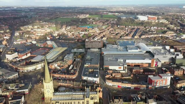 Aerial footage in the town centre of Wakefield in West Yorkshire UK, showing the famous Wakefield Cathedral along with businesses and residential homes and buildings.