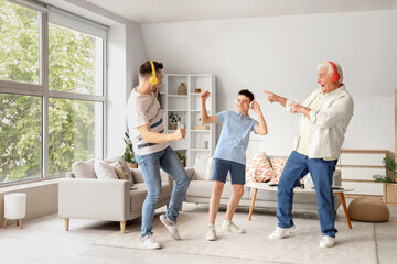 Teenage boy with his dad and grandfather in headphones dancing at home