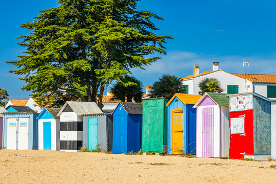 Multi-colored huts of the beach of La Boirie on the Oleron island in Saint-Denis-d'Oléron, France on sunny day with a blue sky