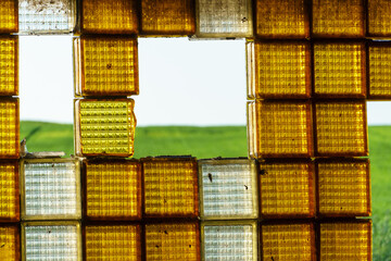 An old window made of glass blocks. Beautiful decorative orange glass blocks.