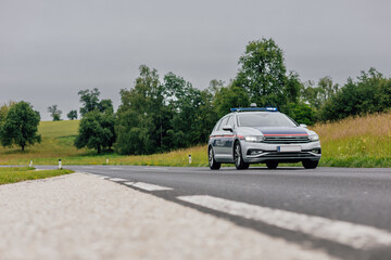 Typical austrian police car in action on an open road. Police in austria, country side road in summer time © Anze