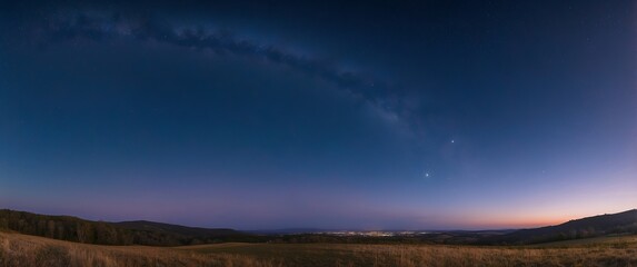 Fototapeta premium A beautiful night sky with twinkling stars over a rural field at twilight, ideal for scenes depicting tranquility, stargazing, and serene landscapes.