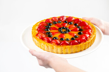 A delicious and appetizing cheesecake in the hands of a man with space for text.  Menu for restaurant and cafe.