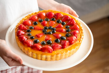A delicious and appetizing cheesecake in the hands of a man with space for text. Menu for restaurant and cafe.