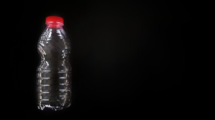 Empty plastic bottle isolated on black background. Negative space for teks