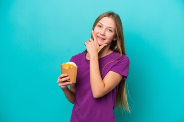 Young Russian woman catching french fries isolated on blue background happy and smiling