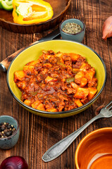 Roast potatoes and ground turkey on wooden table.