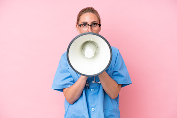 Young surgeon nurse woman isolated on pink background shouting through a megaphone