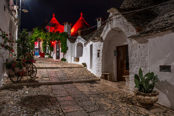 Famous historical old dry stone trulli houses with conical roofs in Alberobello, Italy. Night view