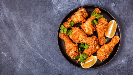 Fried chicken legs with lemon and parsley.