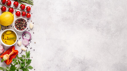 Herbs and condiments on light stone background.
