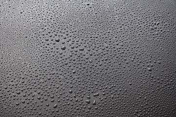 Close up of water droplets on black cover background