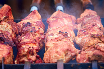 Meat on skewers is grilled over smoking hot coals