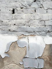 Old brick wall of an abandoned house with peeling paint. Vintage texture or background