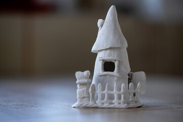 Close-up on a small house made of clay. Homemade clay objects.