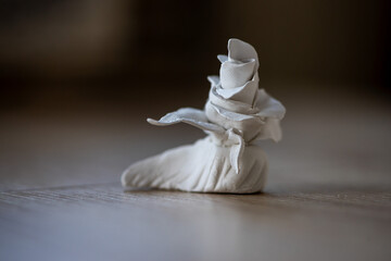 Close-up on a rose made of clay. Homemade clay objects.