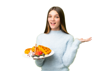 Teenager girl holding waffles over isolated chroma key background with shocked facial expression